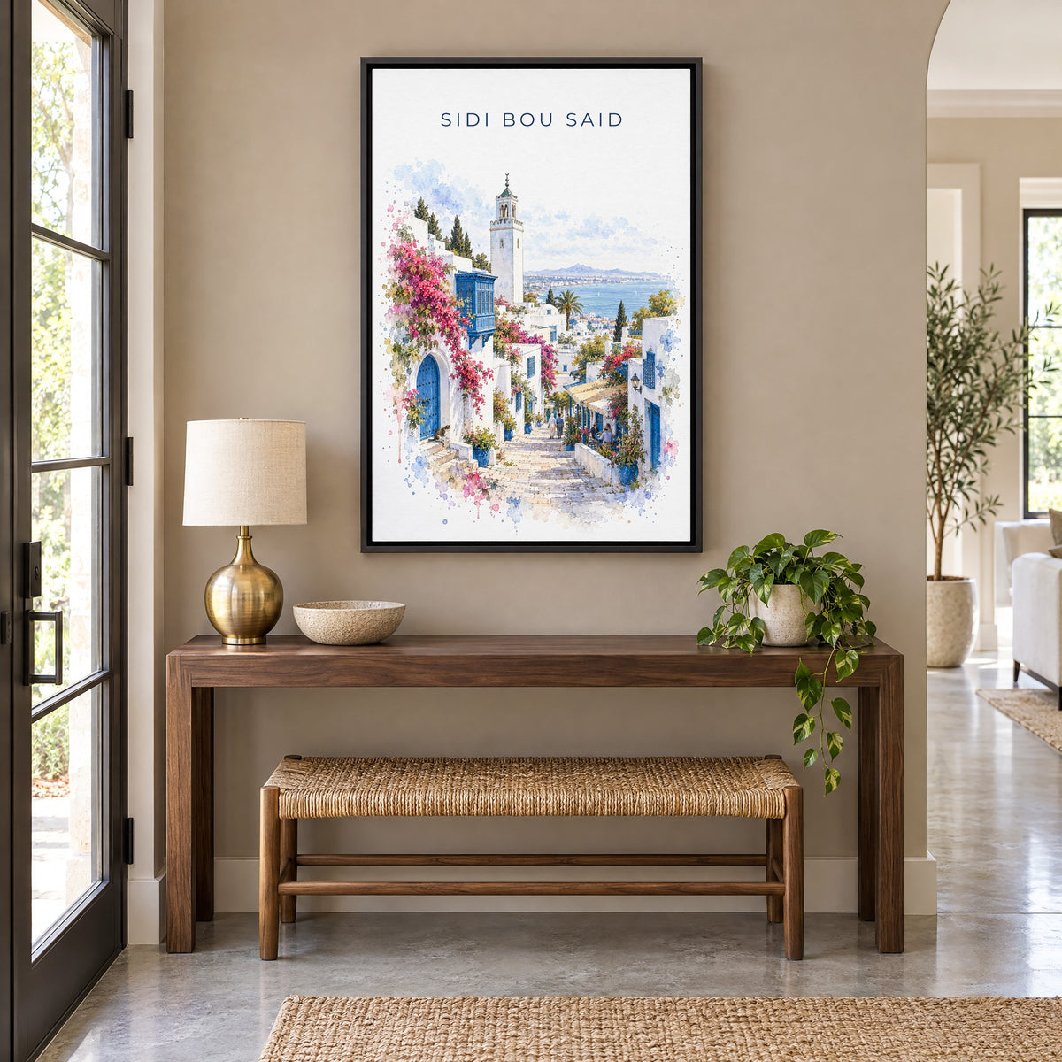 Sidi Bou Said watercolor print as a black floater canvas above a walnut console and woven bench in an entryway