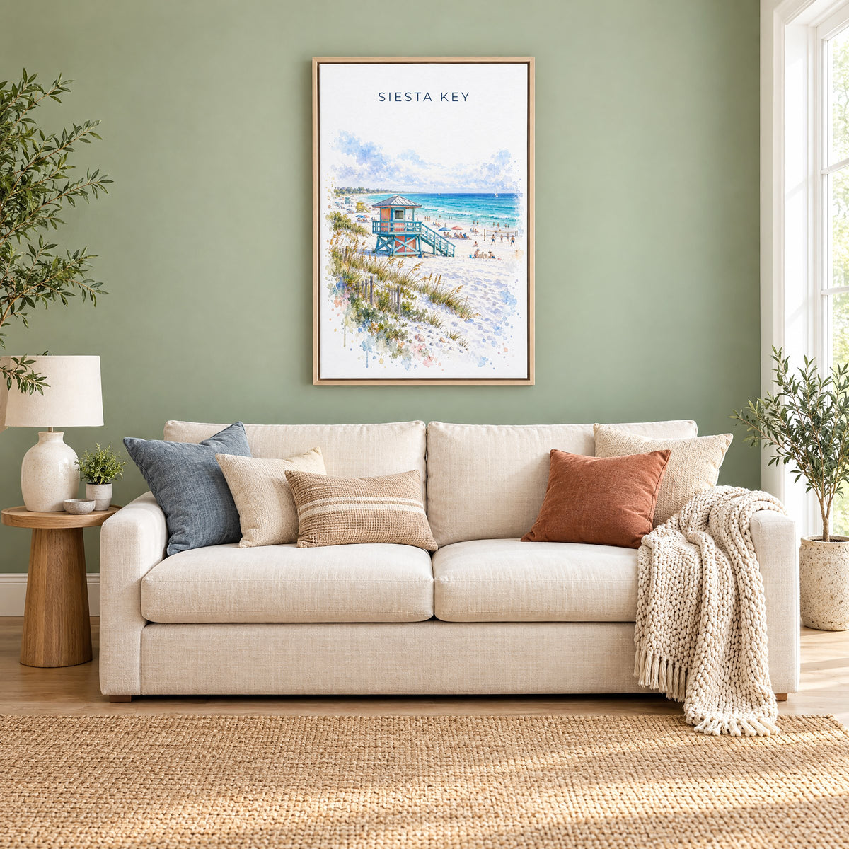 Siesta Key watercolor print as a natural floater canvas above a cream linen sofa on a sage green wall