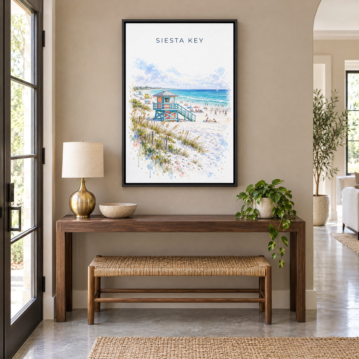 Siesta Key watercolor print as a black floater canvas above a walnut console and woven bench in an entryway