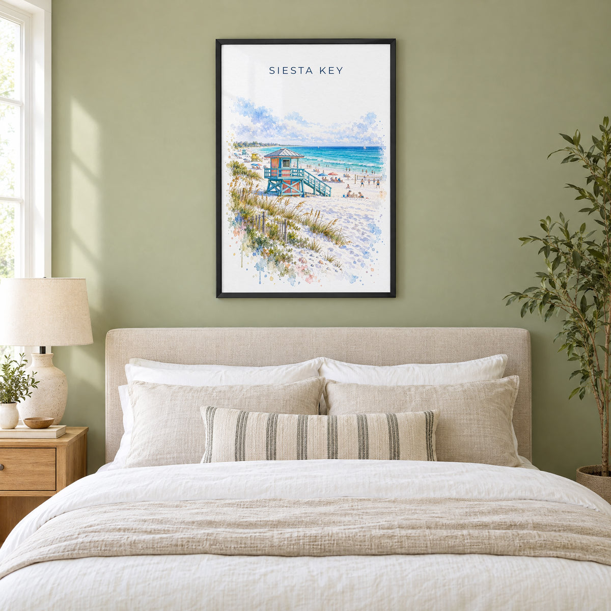 Siesta Key watercolor print in a black frame above an upholstered headboard in a sage green bedroom