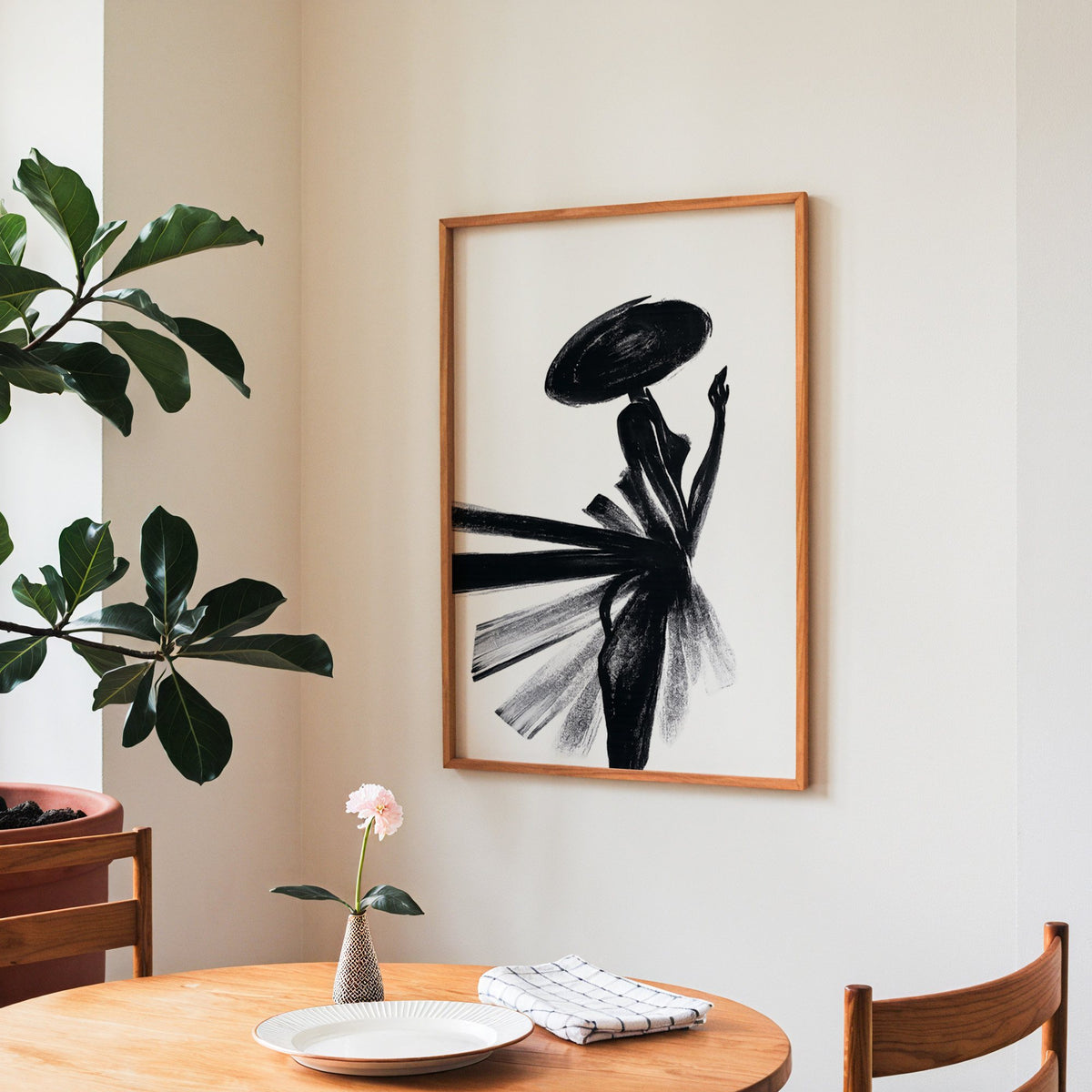 Woman in wide hat with fanned brushstroke skirt print in a teak frame above a round wooden dining table