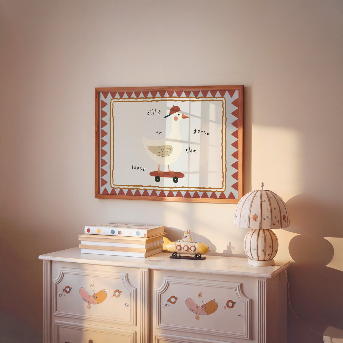 Landscape silly goose on the loose nursery print in a cherry wood frame above a painted dresser and lamp