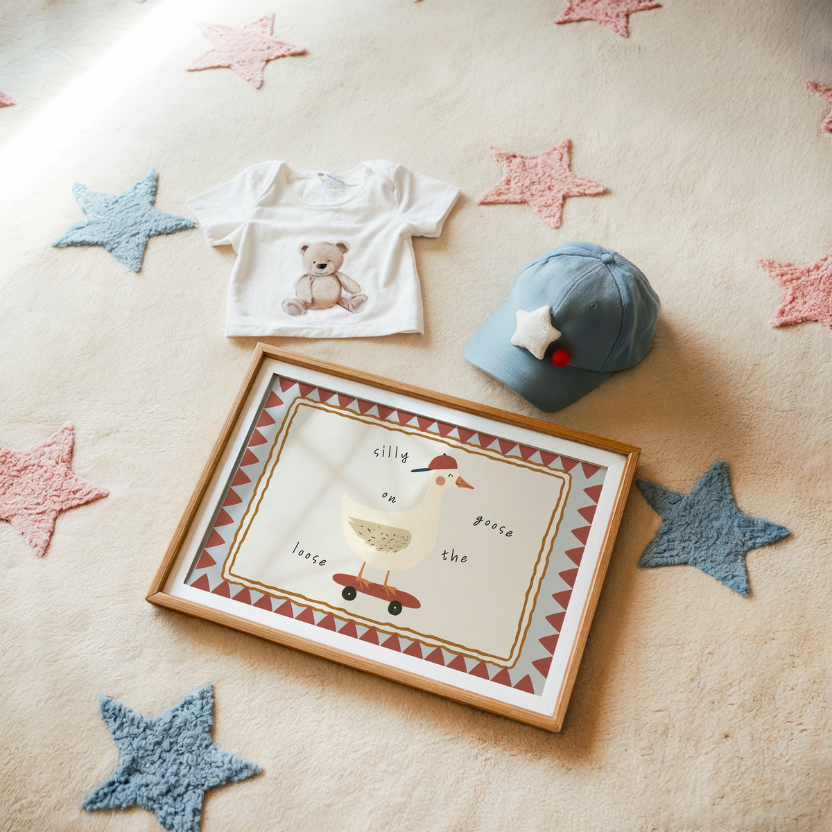 Landscape silly goose on the loose nursery print in a matted oak frame on a star rug with a baby tee