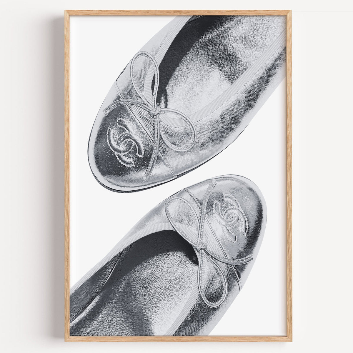 Silver cap toe ballet flats close-up print in a light oak frame on a plain white wall