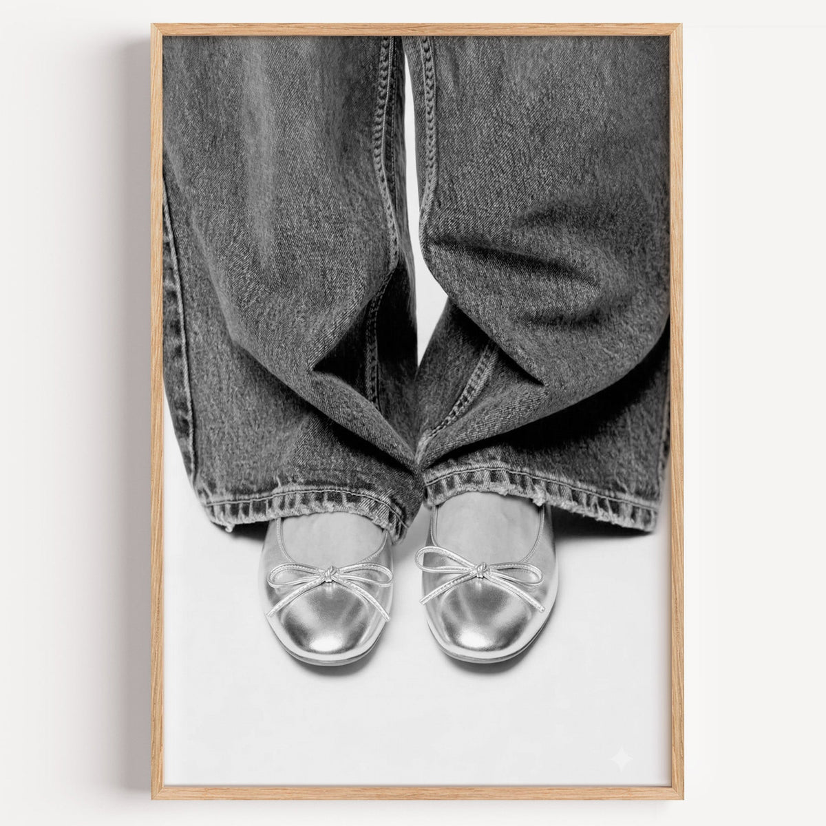 Silver ballet flats under wide-leg jeans print in a light oak frame on a plain white wall
