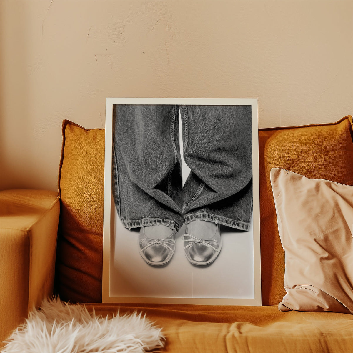 Silver ballet flats under wide-leg jeans print in a white frame leaning on a mustard velvet sofa