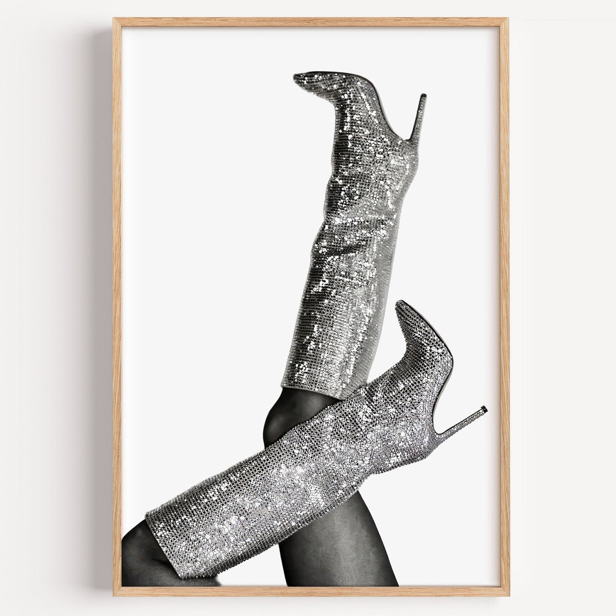 Silver sequin knee-high stiletto boots print in a light oak frame on a plain white wall
