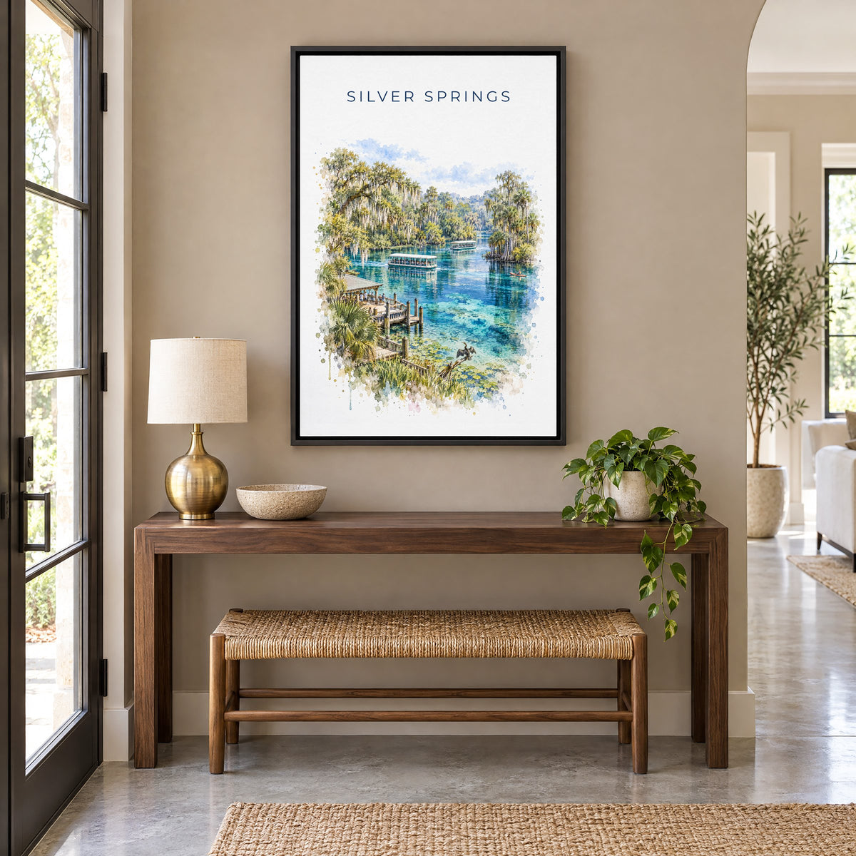 Silver Springs State Park watercolor print as a black floater canvas above a walnut console and woven bench in an entryway