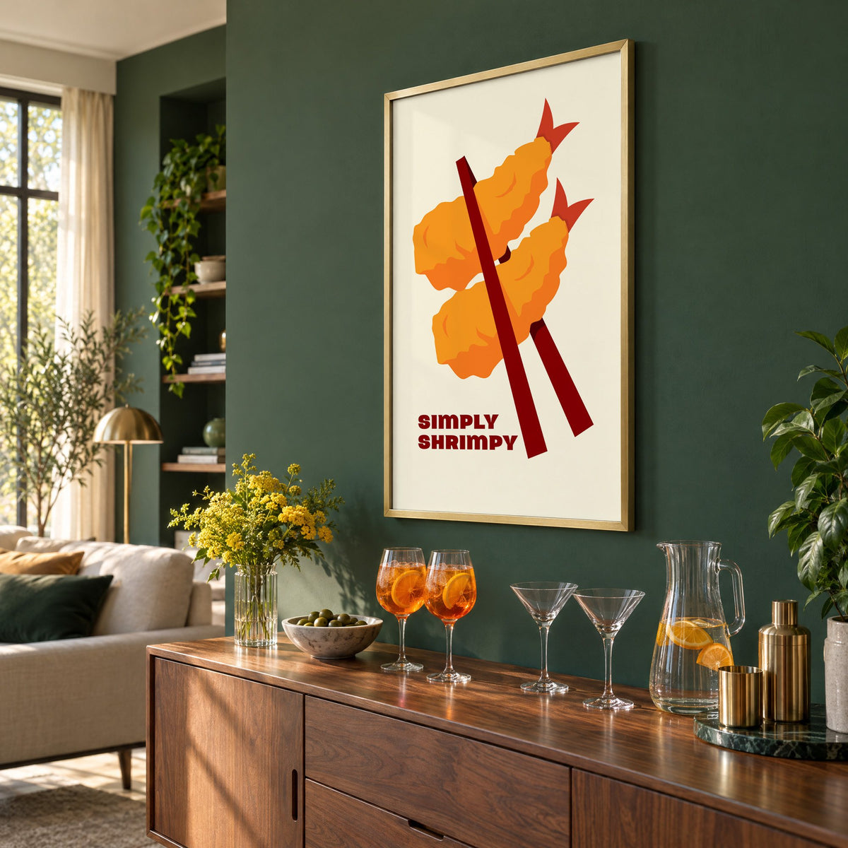 SIMPLY SHRIMPY tempura shrimp chopsticks print in a brass frame on a bottle green wall above a sideboard with spritz and martini glasses, seen at an angle