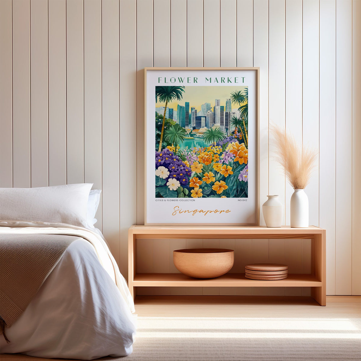 Singapore flower market print in an oak frame on a wood bench against a white shiplap bedroom wall with pampas grass