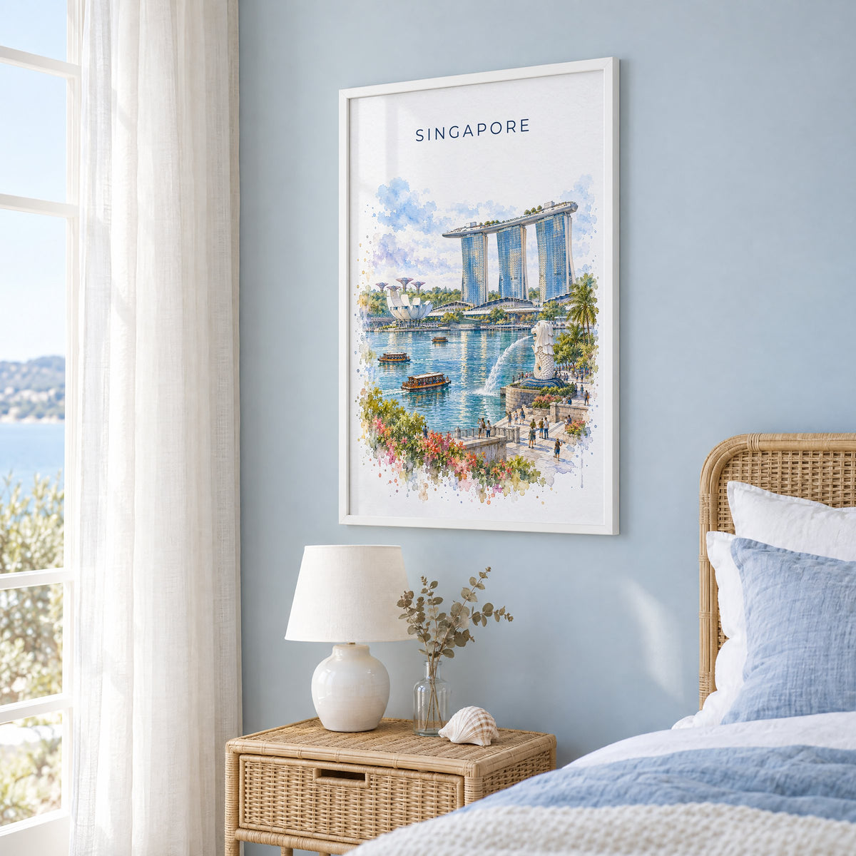 Singapore watercolor print in a white frame on a pale blue wall beside a rattan bed in a coastal bedroom