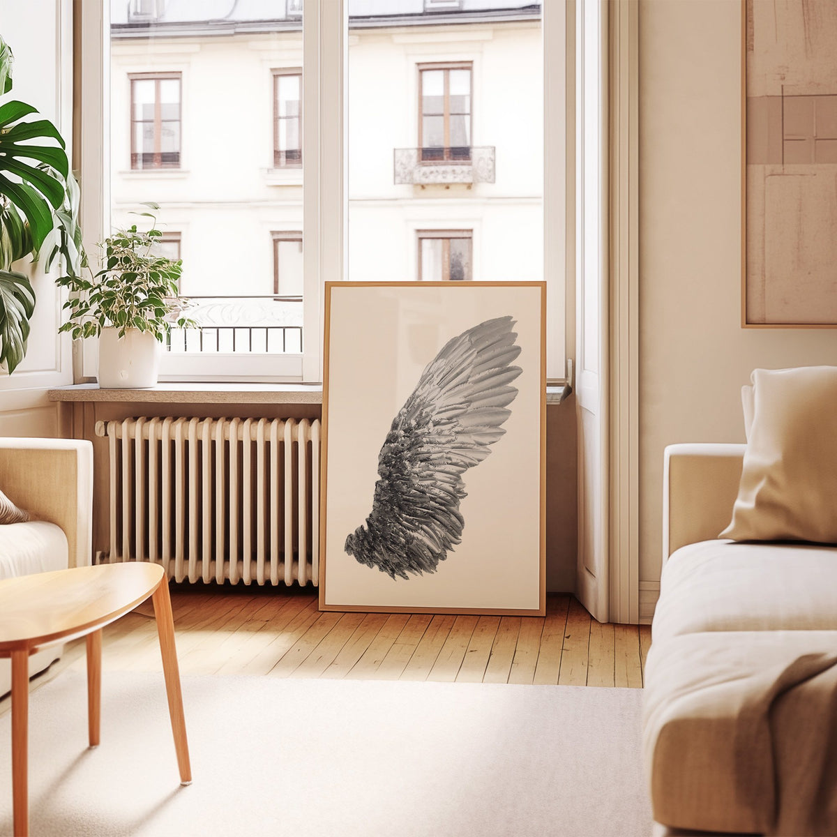 Single silver metallic wing on white print in an oak frame leaning by a French window in a living room