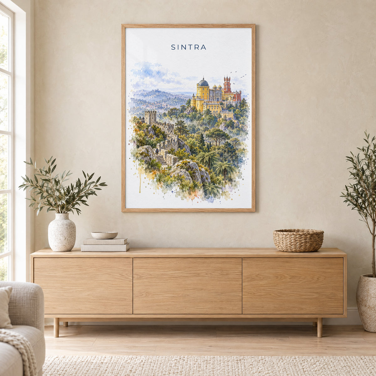 Sintra watercolor print in an oak frame above a light wood sideboard in a Scandinavian living room