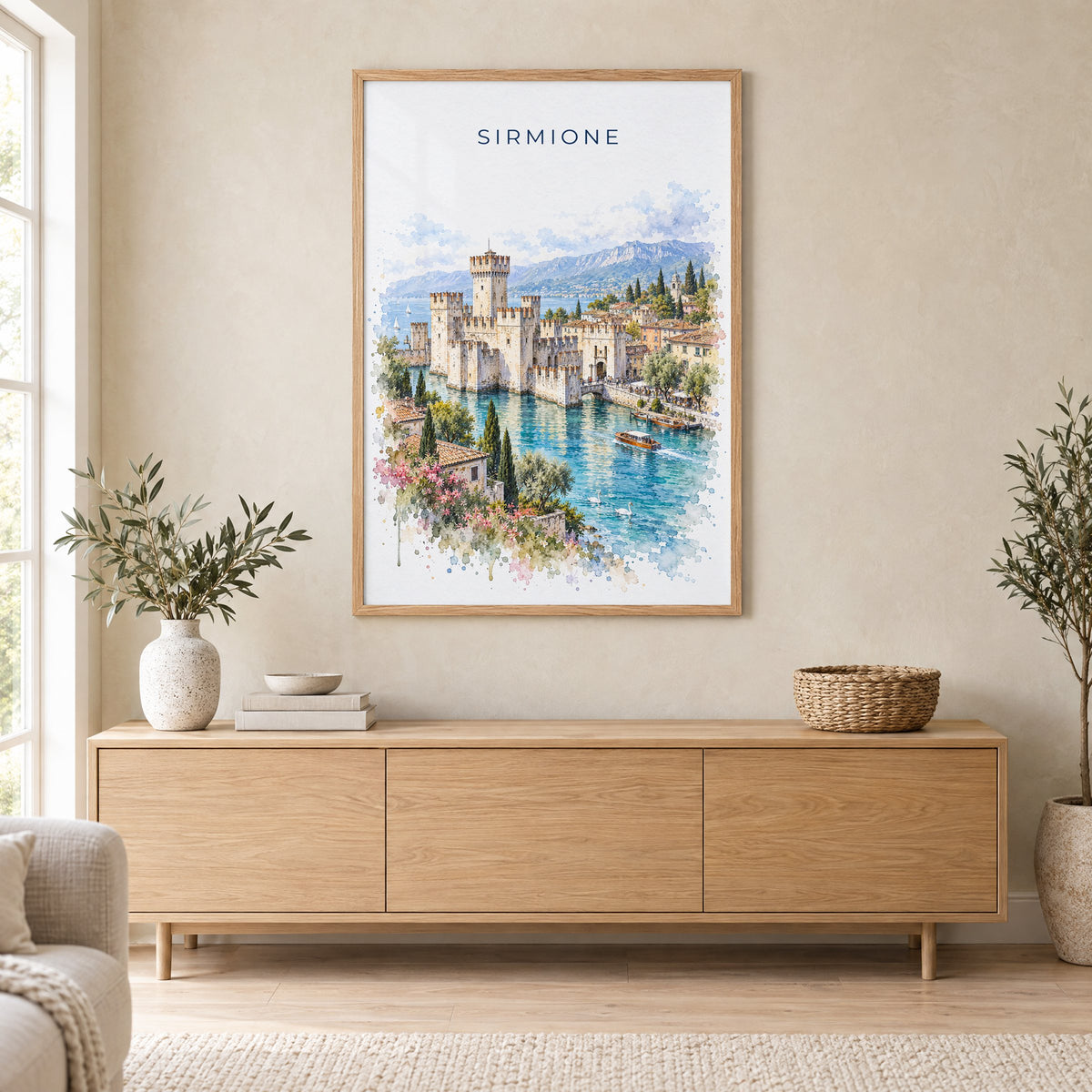 Sirmione watercolor print in an oak frame above a light wood sideboard in a Scandinavian living room