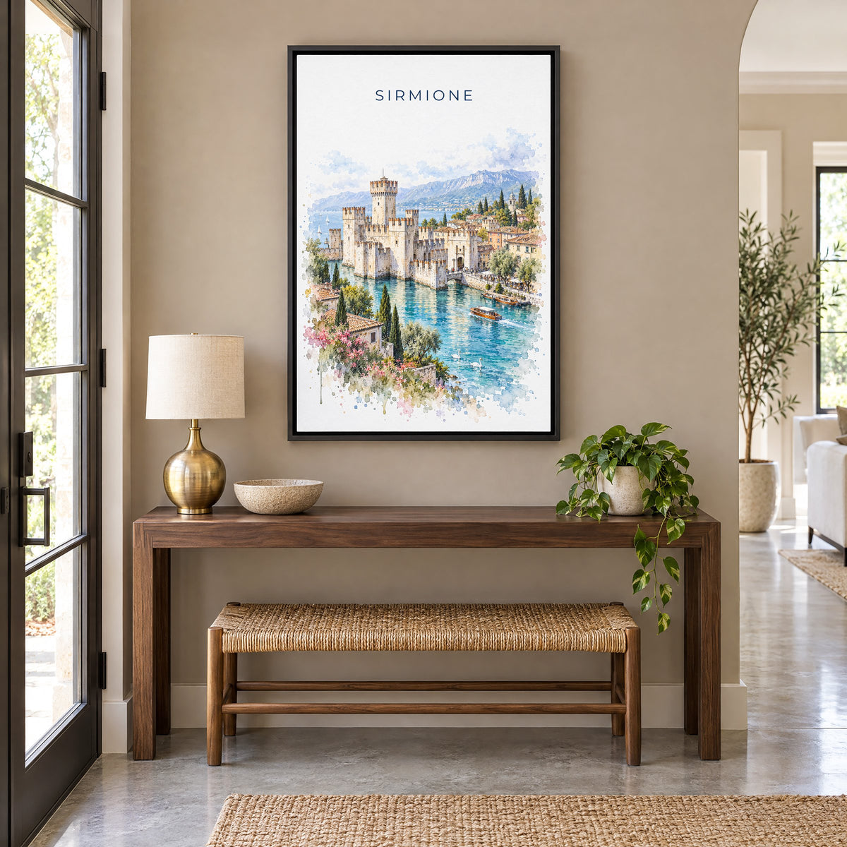 Sirmione watercolor print as a black floater canvas above a walnut console and woven bench in an entryway