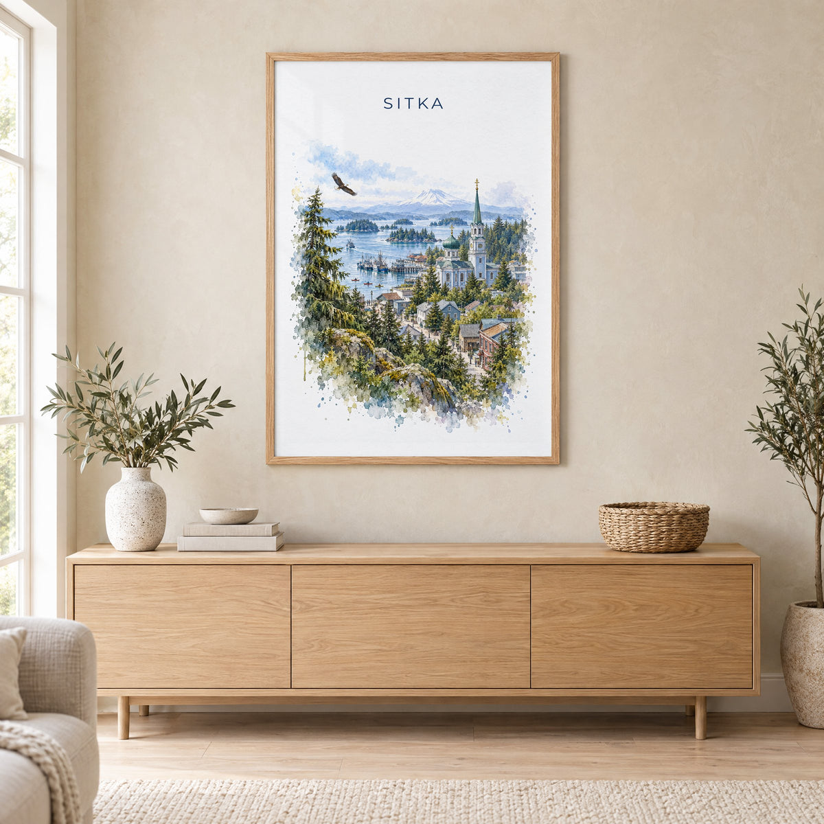 Sitka, Alaska watercolor print in an oak frame above a light wood sideboard in a Scandinavian living room