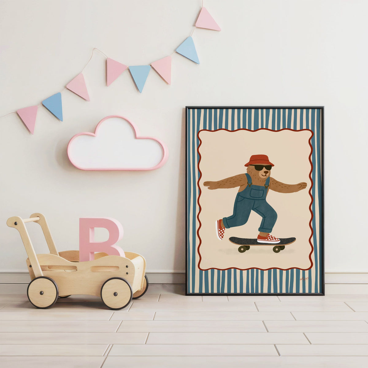 Bear in overalls on a skateboard nursery print in a black frame under pastel bunting by a wooden baby walker