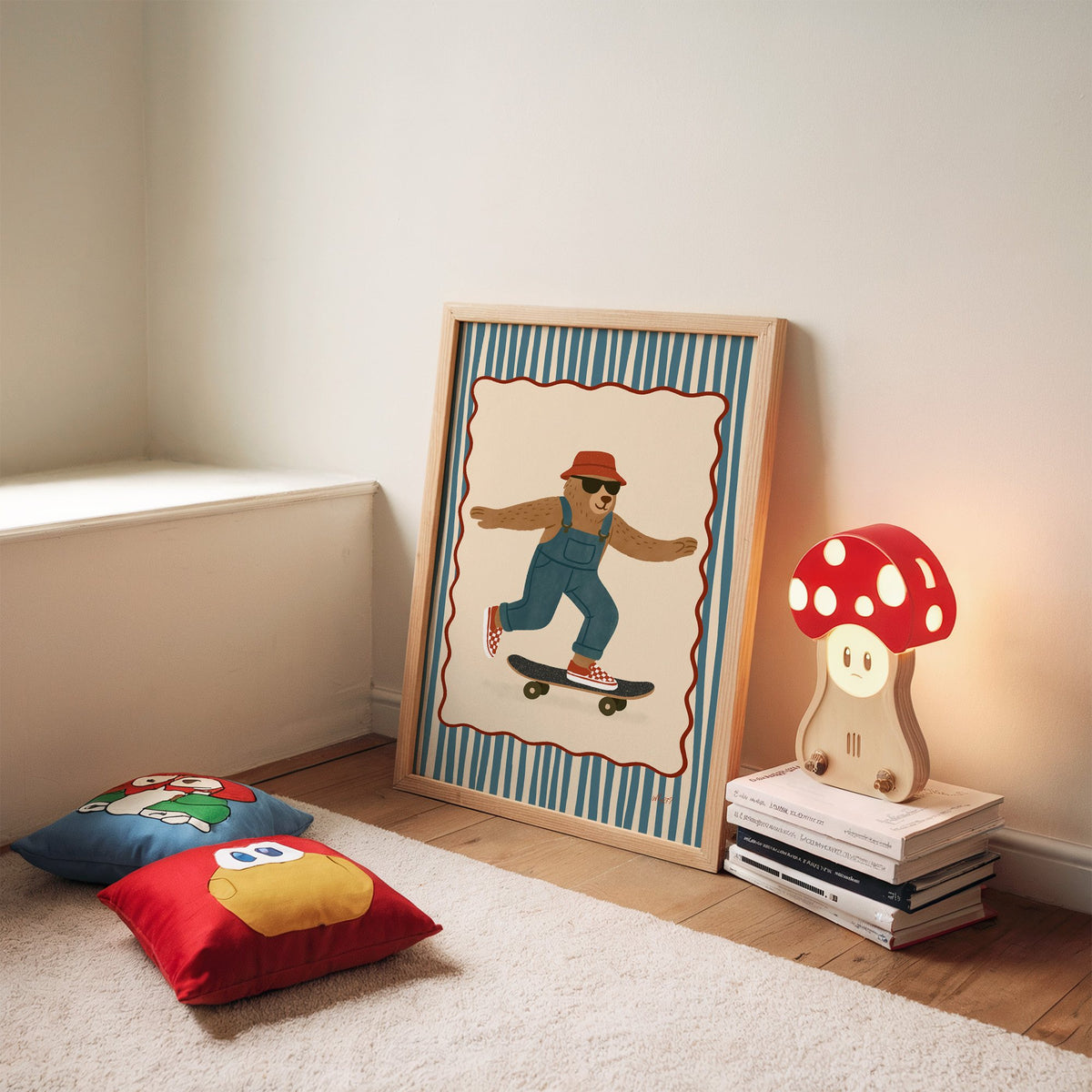 Bear in overalls on a skateboard nursery print in an oak frame leaning on a rug beside a mushroom lamp and floor cushions
