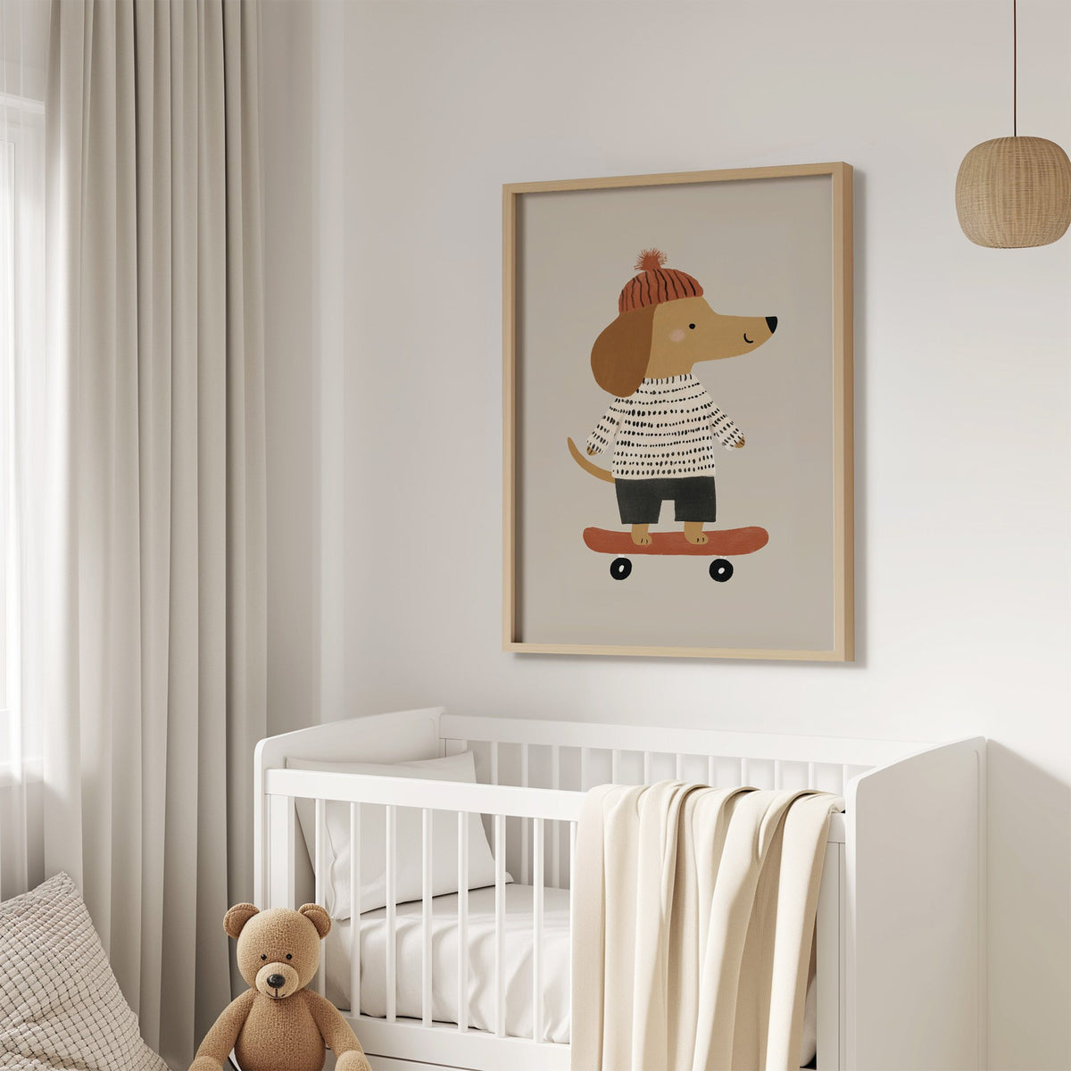 Skateboard dog pompom beanie nursery print in an oak frame above a white crib with a teddy bear