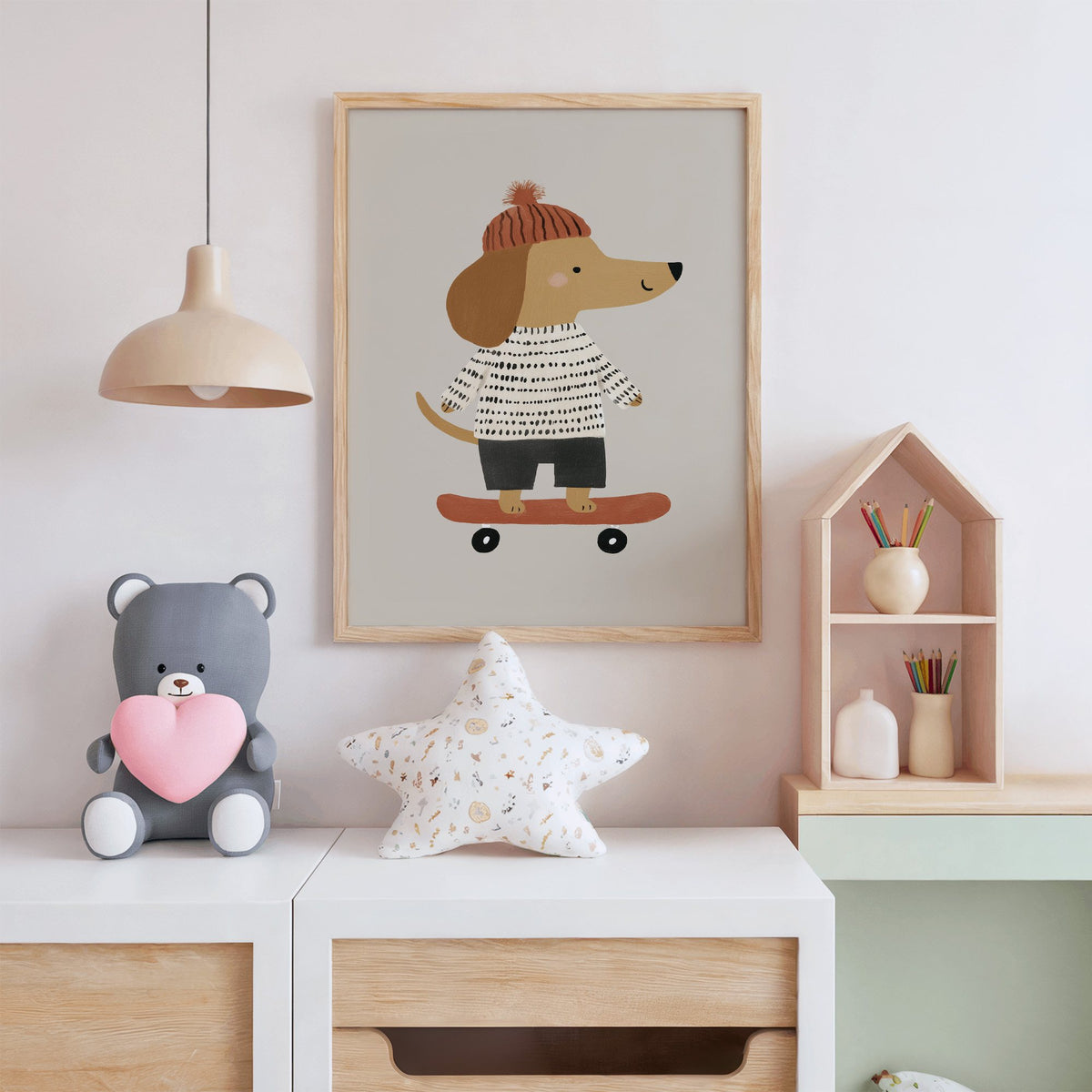 Skateboard dog pompom beanie nursery print in an oak frame above a white dresser with a star pillow and house shelf