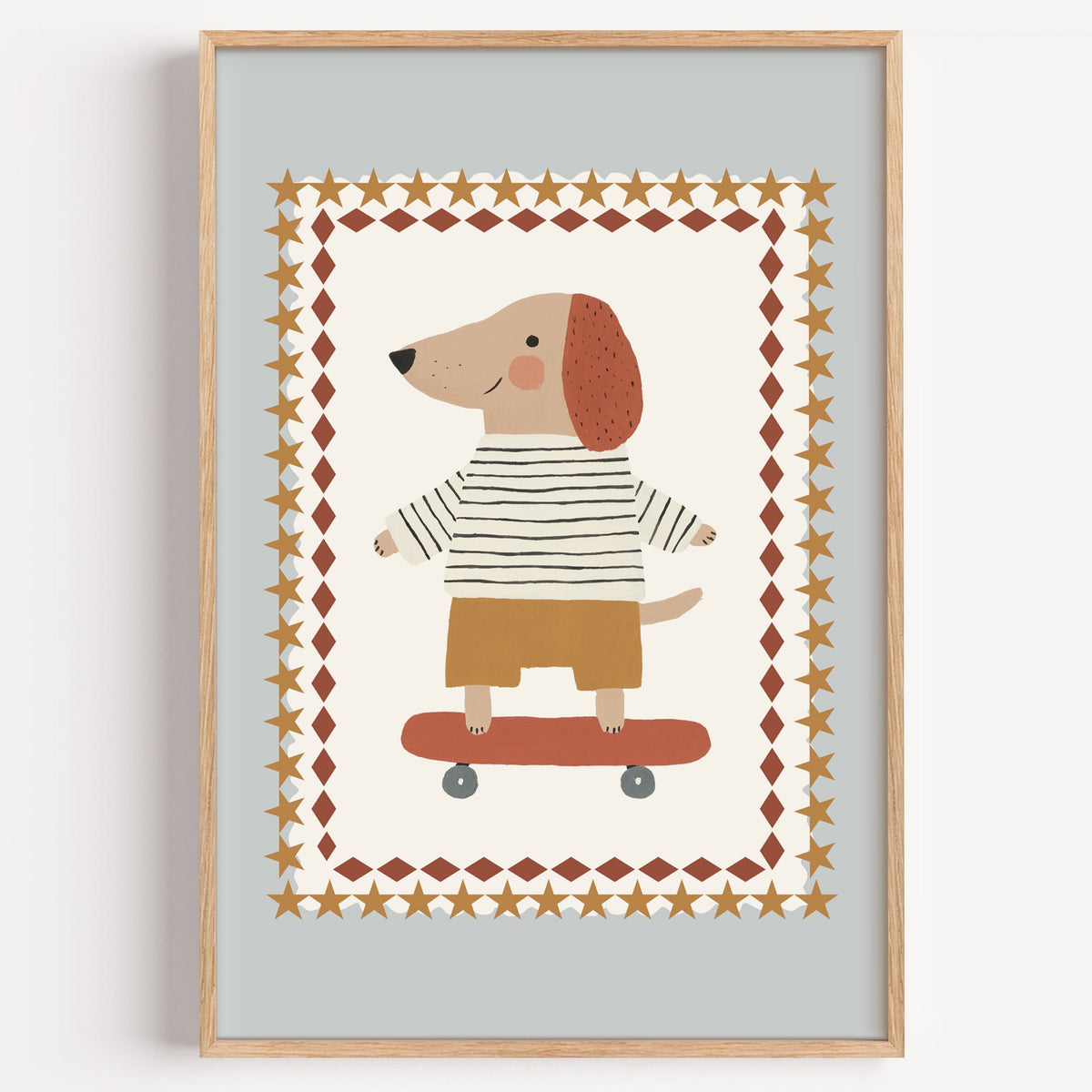 Skateboard dog star frame nursery print in a light oak frame on a plain white wall