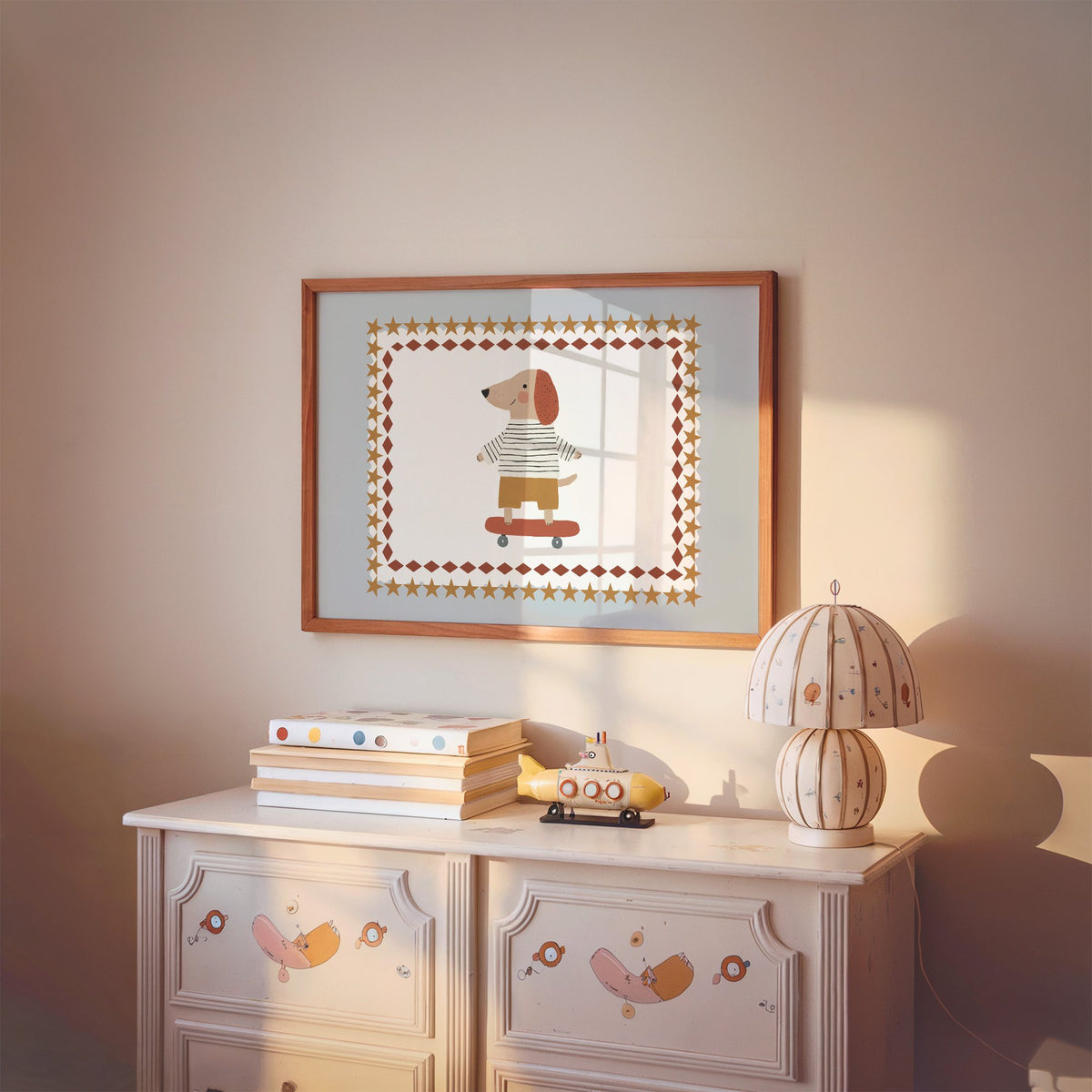 Landscape skateboard dog star frame nursery print in a cherry wood frame above a painted dresser and lamp