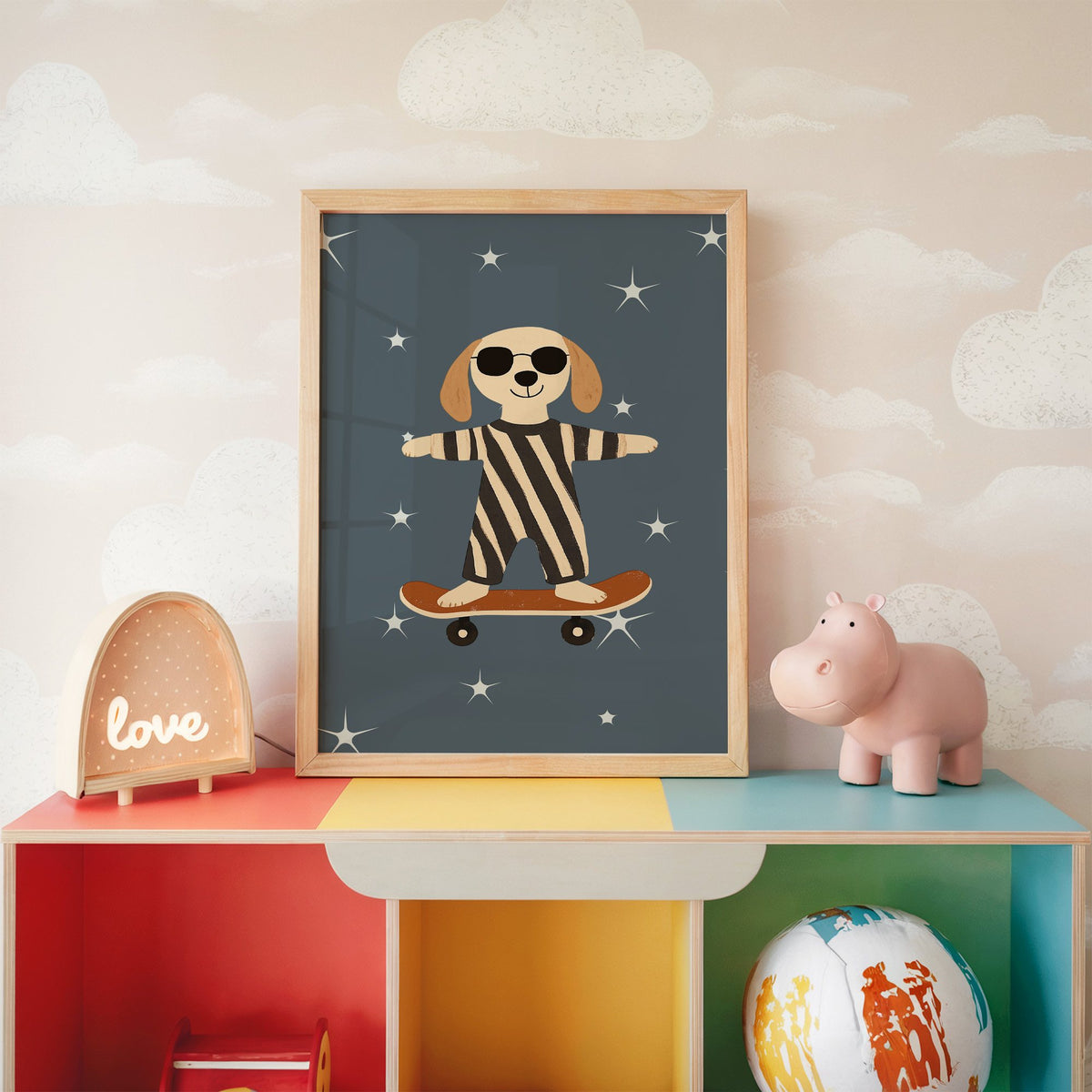 Skateboard dog starry night nursery print in an oak frame on a rainbow toy shelf against cloud wallpaper