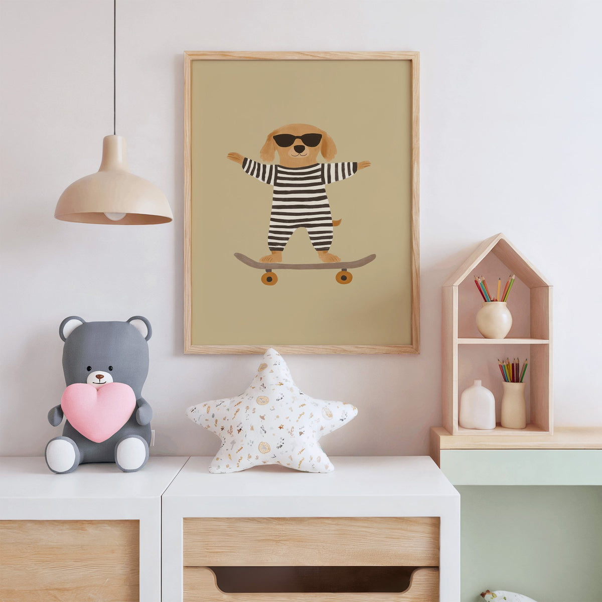 Skateboard dog striped onesie nursery print in an oak frame above a white dresser with a star pillow and house shelf