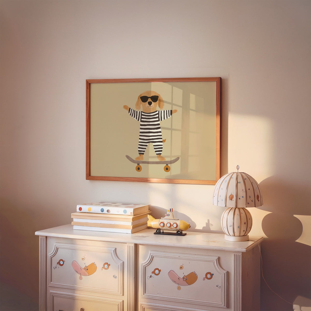 Landscape skateboard dog striped onesie nursery print in a cherry wood frame above a painted dresser and lamp