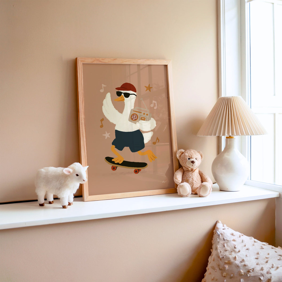Goose on skateboard with boombox nursery print in an oak frame on a window ledge with a toy lamb and teddy