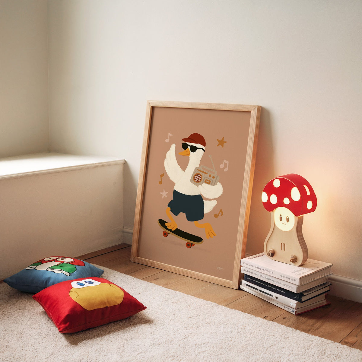 Goose on skateboard with boombox nursery print in an oak frame leaning on a rug beside a mushroom lamp and floor cushions