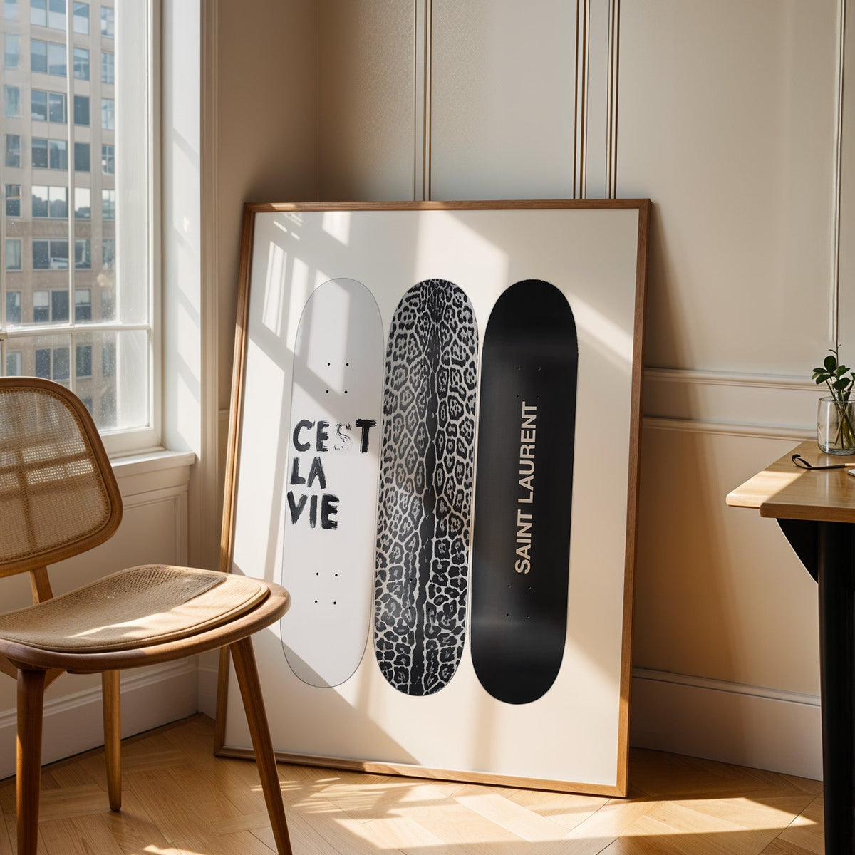 Three skateboards with leopard deck and lettering print in an oak frame leaning in a sunlit corner beside a cane chair