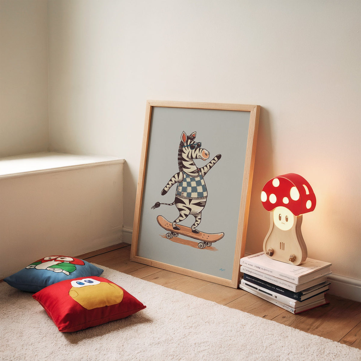Zebra on orange skateboard nursery print in an oak frame leaning on a rug beside a mushroom lamp and floor cushions