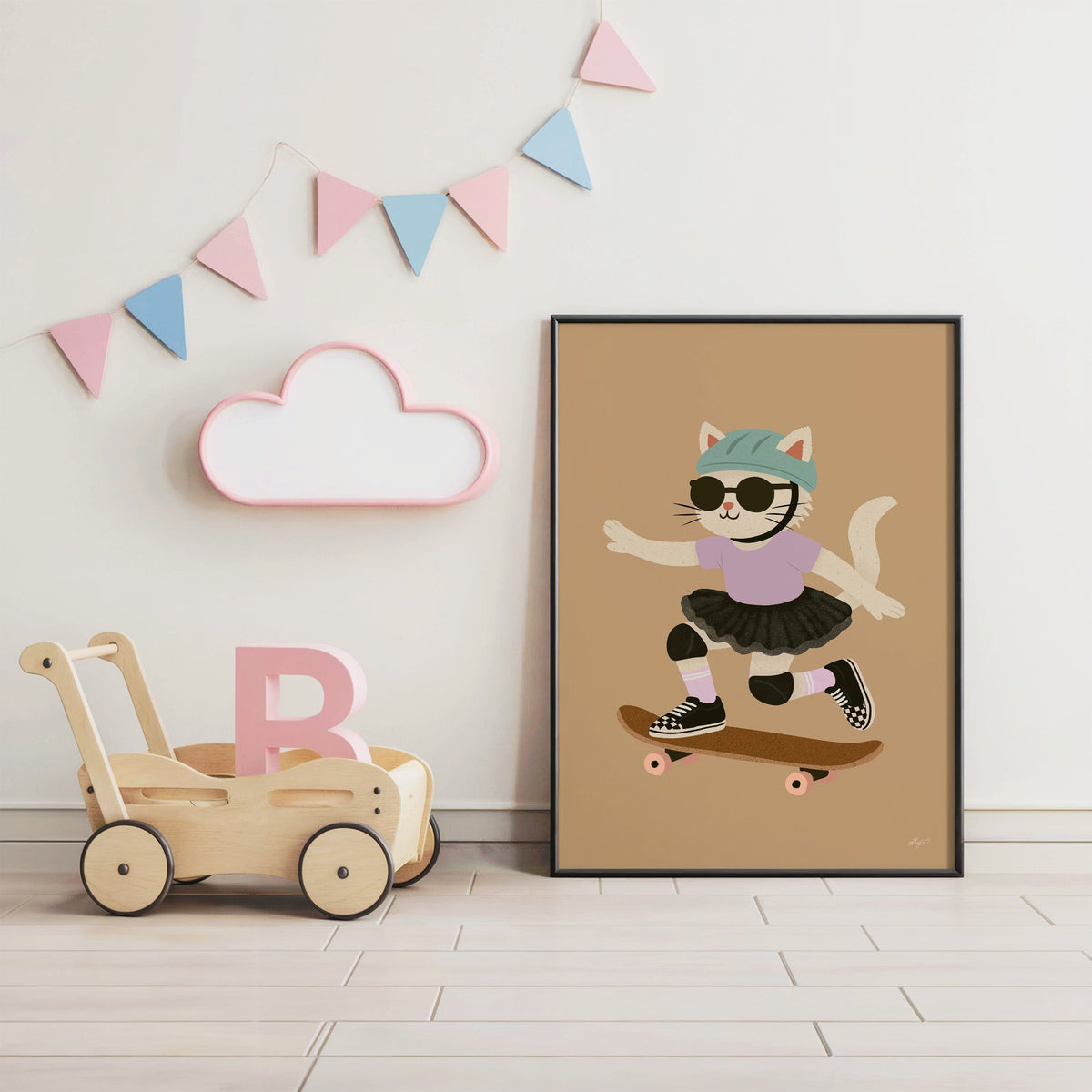 Skater cat in black tutu nursery print in a black frame under pastel bunting by a wooden baby walker