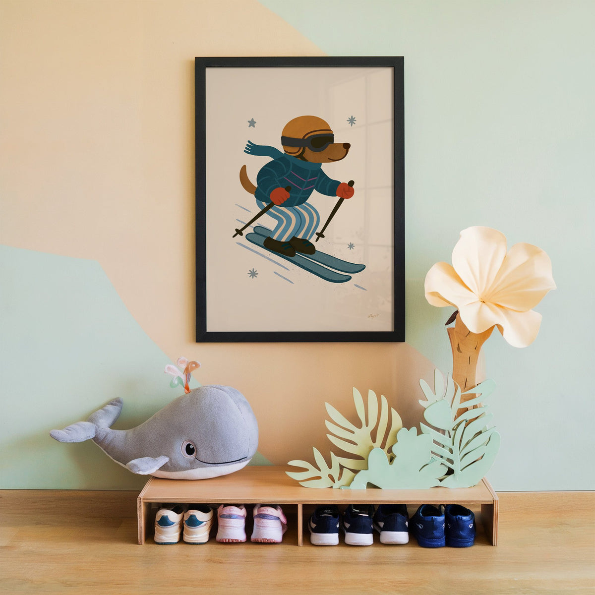 Skiing dog in puffer jacket nursery print in a black frame on a mint and peach wall above a whale plush
