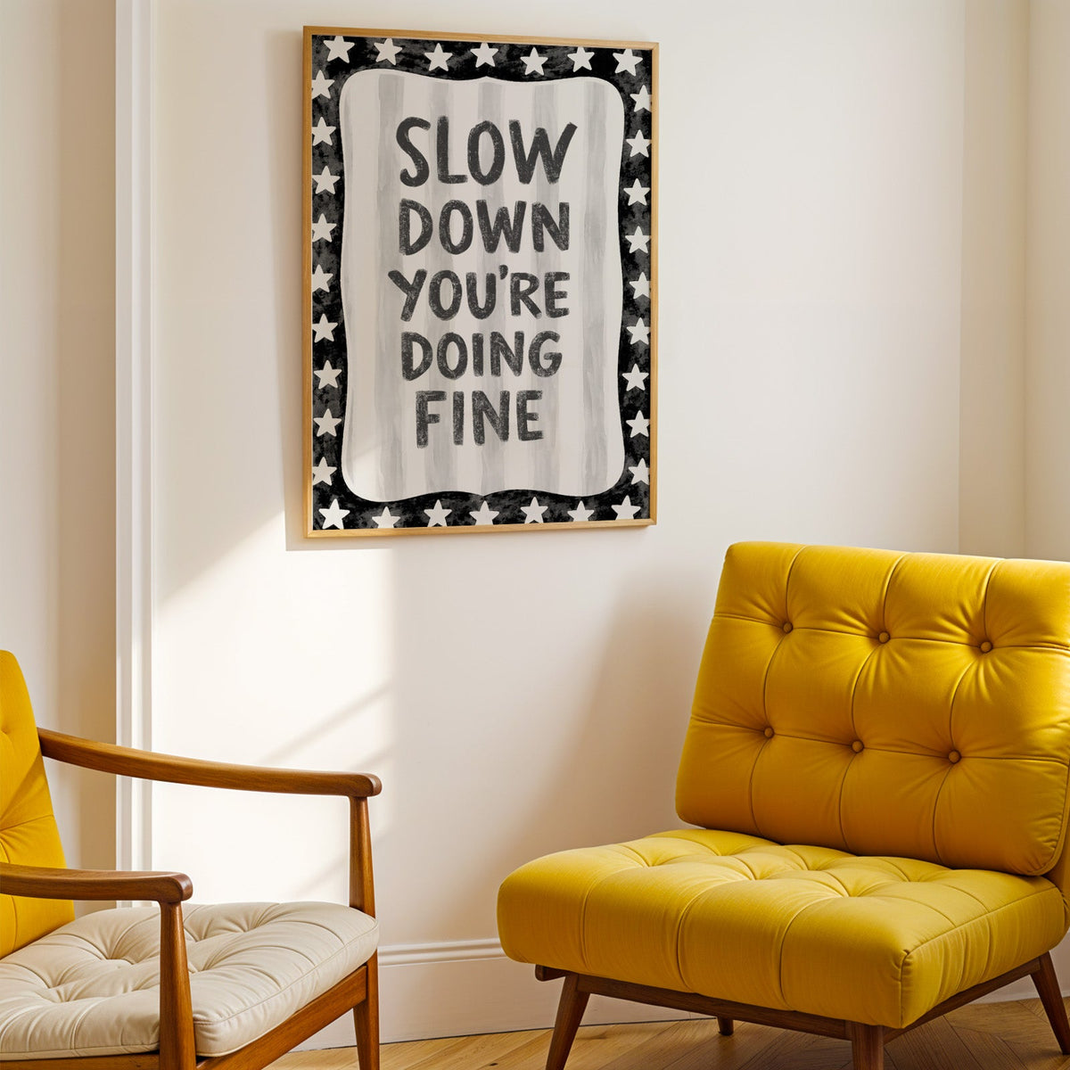 Slow down you're doing fine quote with star border print shown in a gold frame above a mustard yellow tufted armchair