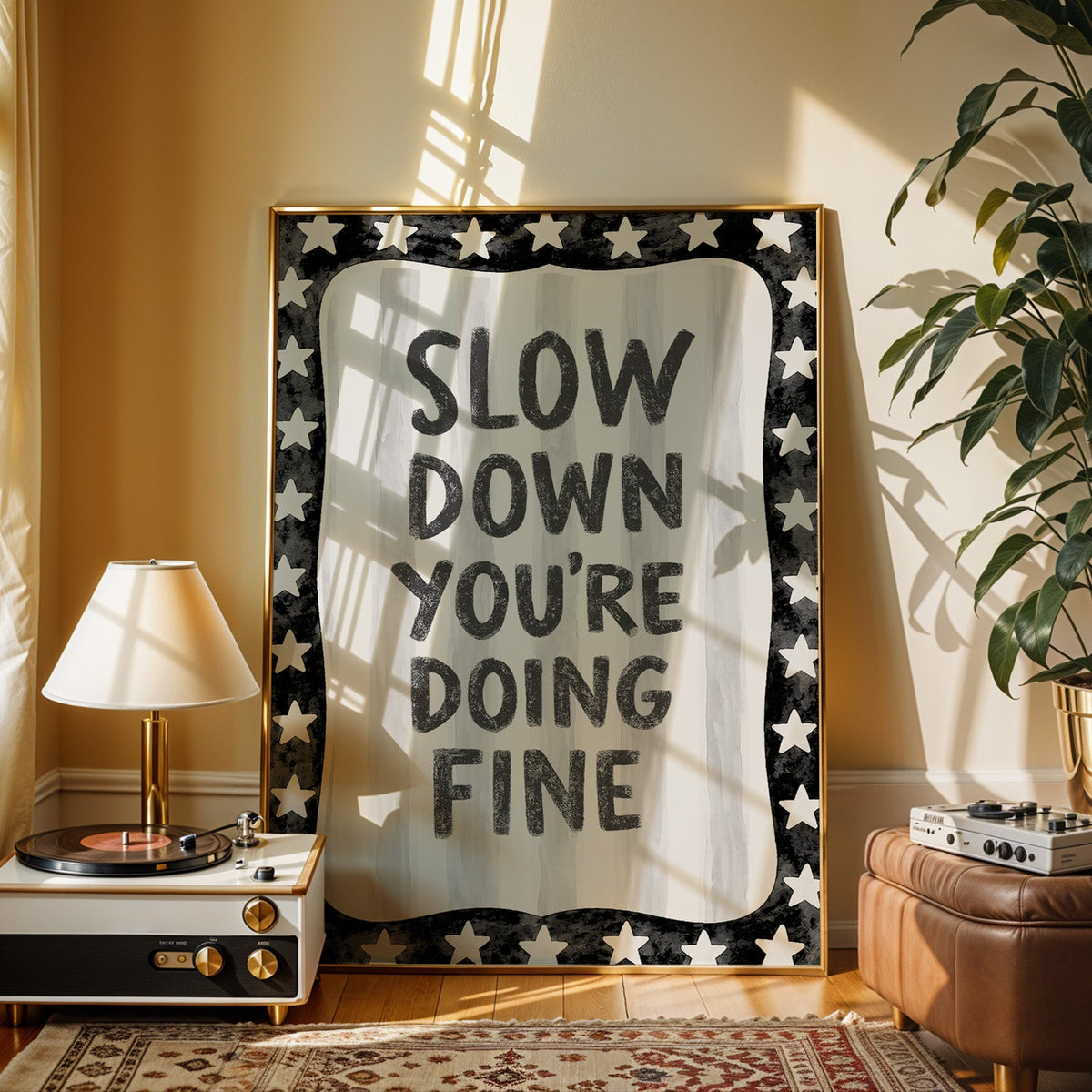Slow down you're doing fine quote with star border print shown in a gold frame beside a record player and table lamp
