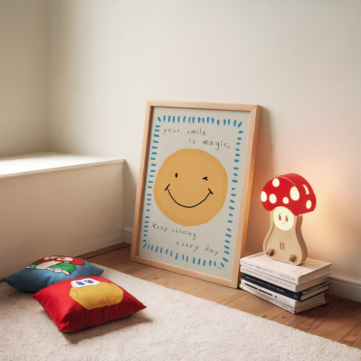 Winking smiley face quote nursery print in an oak frame leaning on a rug beside a mushroom lamp and floor cushions