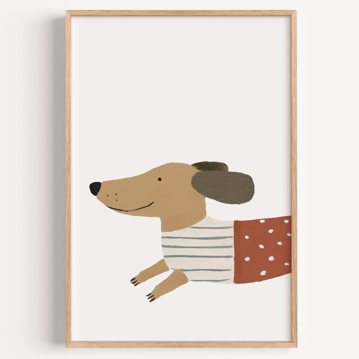 Smiling dachshund close-up nursery print in a light oak frame on a plain white wall