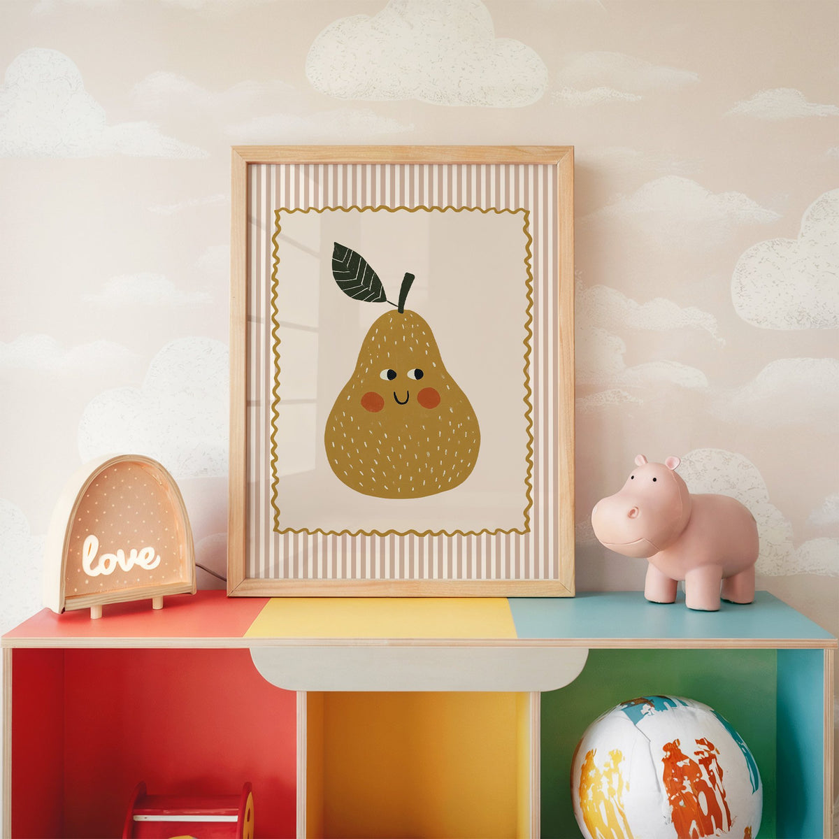 Smiling pear pink stripe nursery print in an oak frame on a rainbow toy shelf against cloud wallpaper