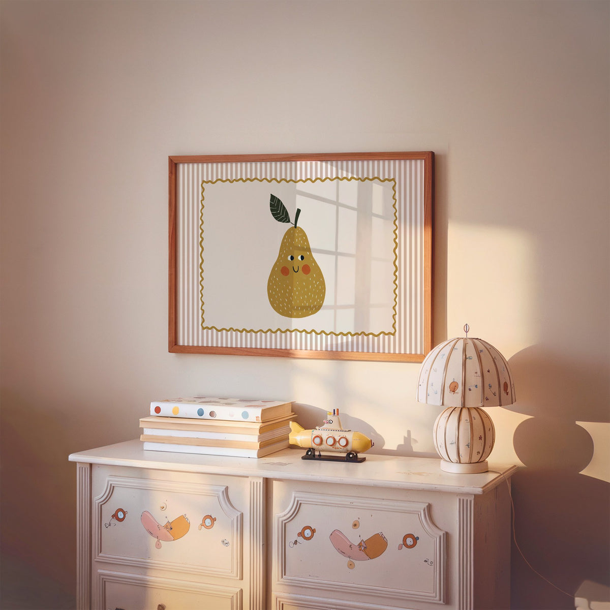 Landscape smiling pear pink stripe nursery print in a cherry wood frame above a painted dresser and lamp