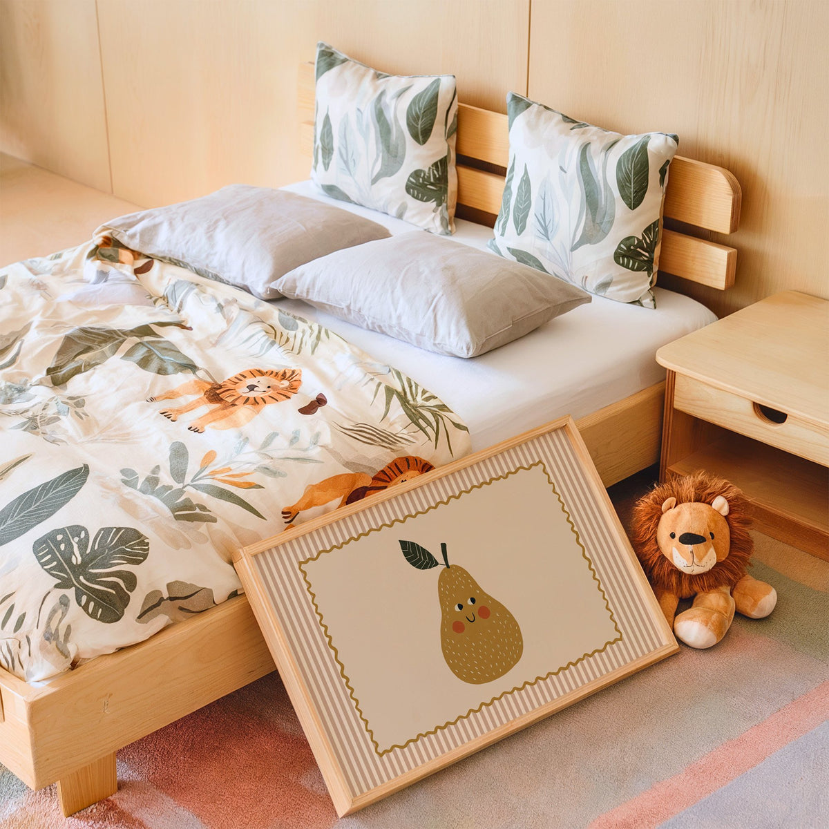 Landscape smiling pear pink stripe nursery print in an oak frame leaning on a kids bed by a lion plush