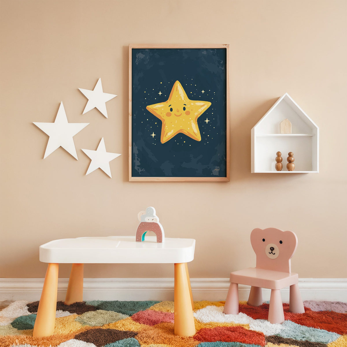 Smiling yellow star on navy nursery print in an oak frame on a peach wall above a kids table with wall stars