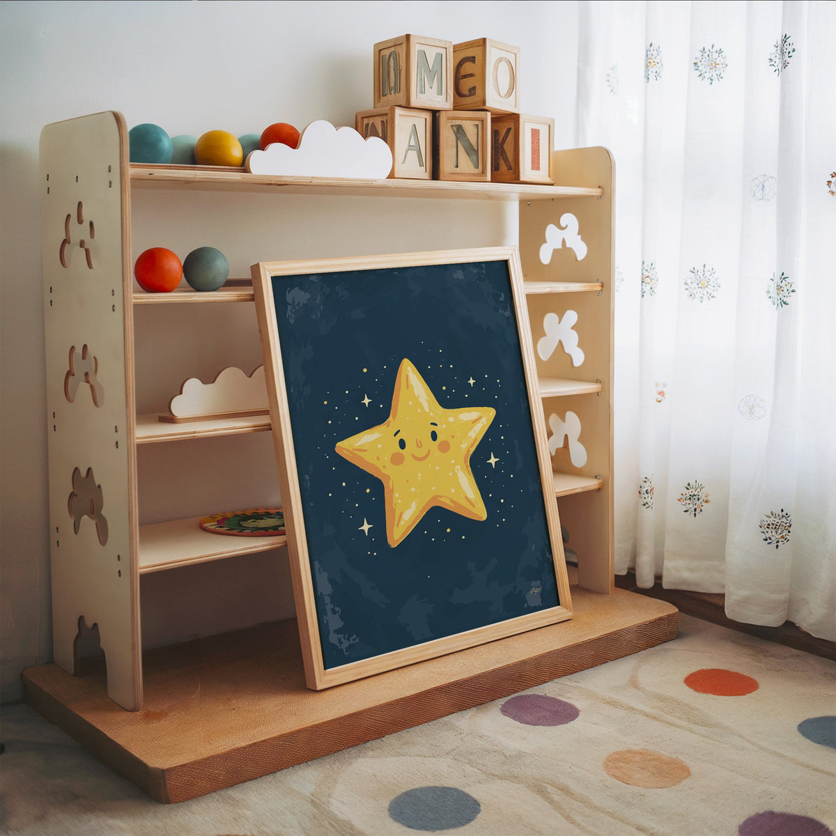 Smiling yellow star on navy nursery print in an oak frame leaning on a toy shelf with wooden letter blocks