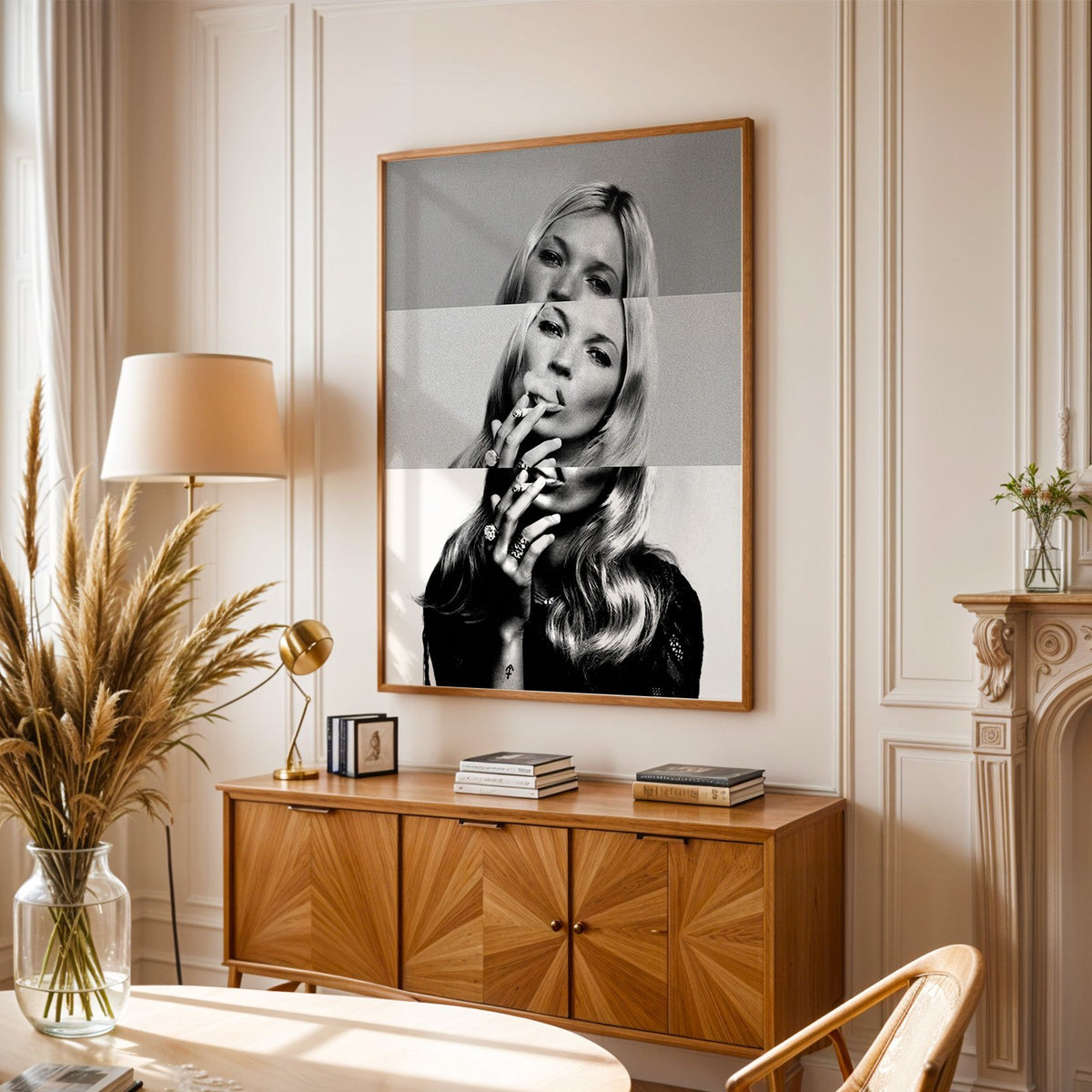 Sliced black and white smoking woman portrait print in an oak frame above a sunburst wood sideboard with pampas grass