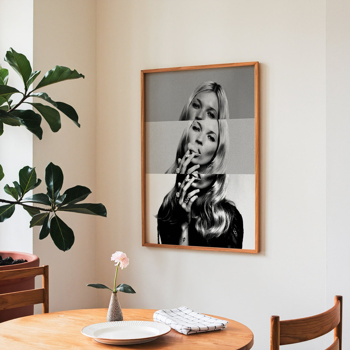 Sliced black and white smoking woman portrait print in a teak frame above a round wooden dining table