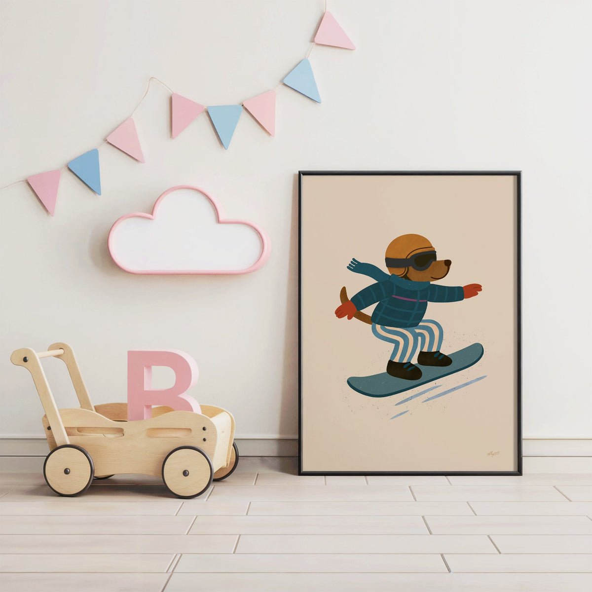 Snowboarding dog with arms wide nursery print in a black frame under pastel bunting by a wooden baby walker