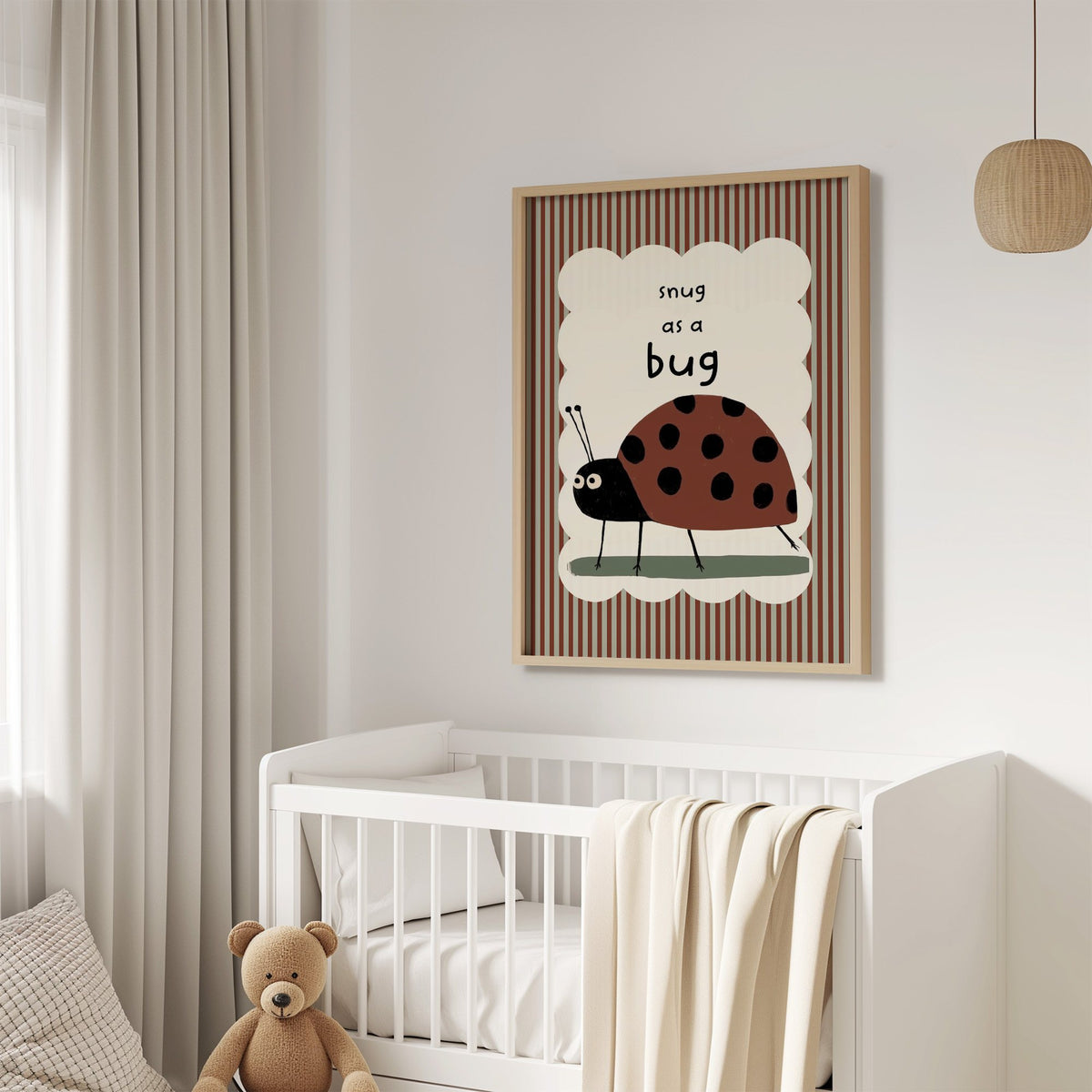 Snug as a bug ladybug nursery print in an oak frame above a white crib with a teddy bear