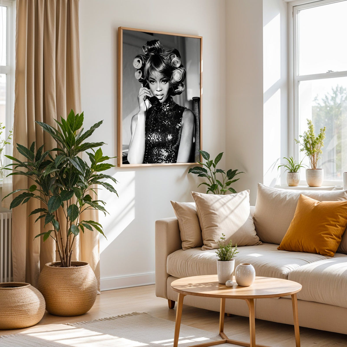 Woman with soda can hair rollers on telephone print in an oak frame above a cream sofa beside woven planters