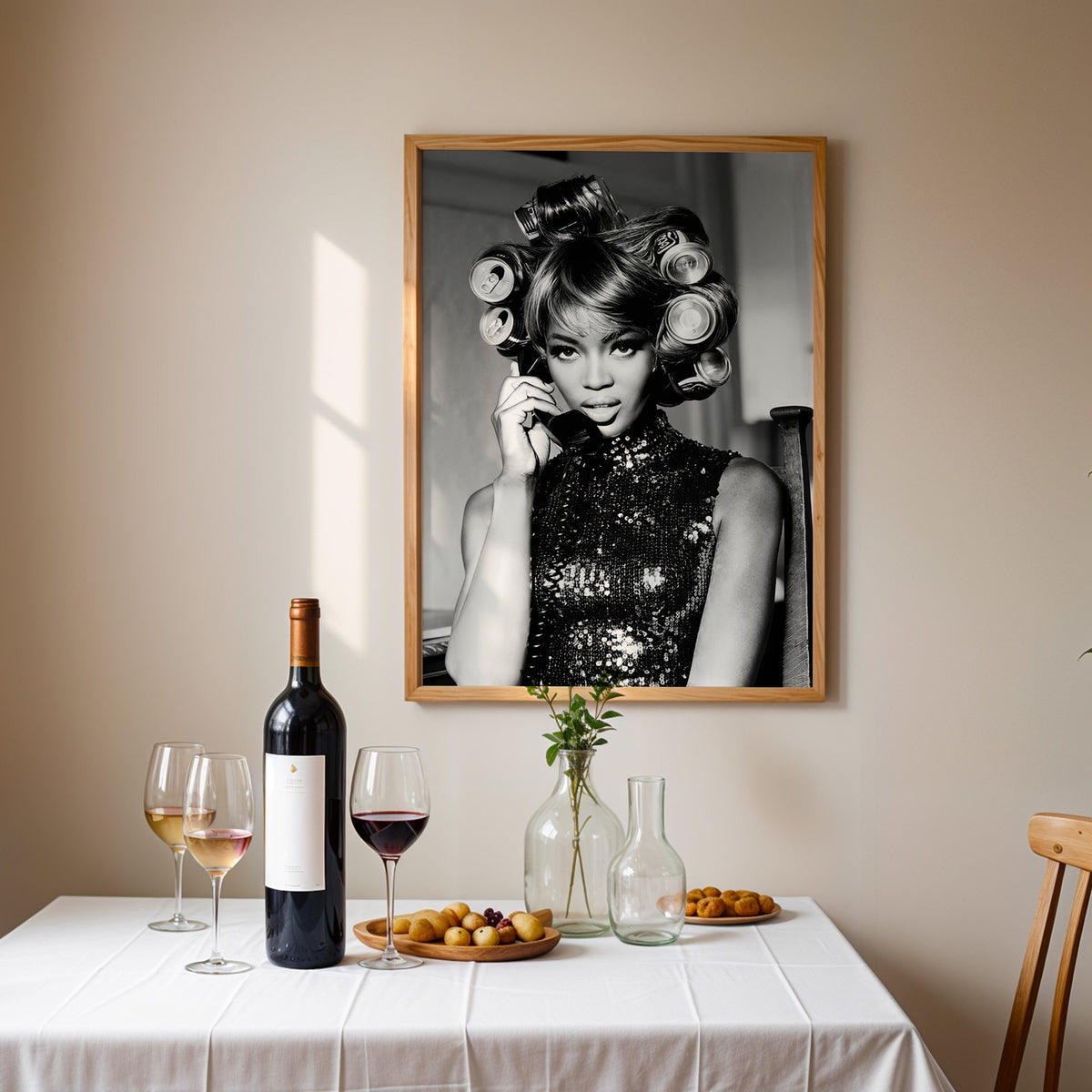 Woman with soda can hair rollers on telephone print in an oak frame above a table set with red wine and glasses
